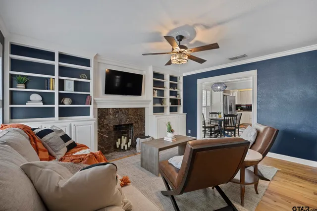a living room with furniture a fireplace and a flat screen tv