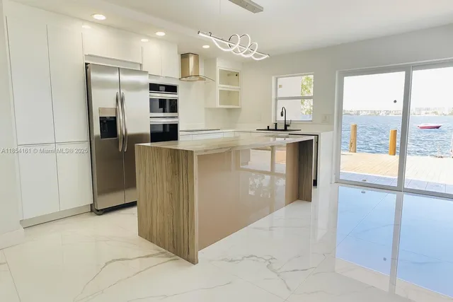 a kitchen with stainless steel appliances granite countertop a refrigerator and a sink