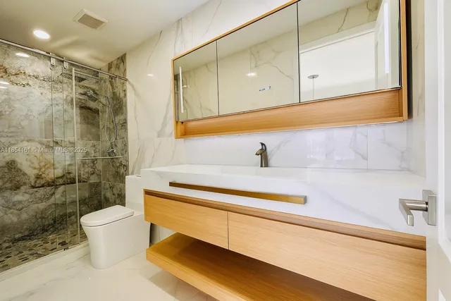 a bathroom with a sink a toilet and shower