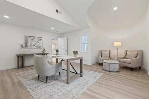 an empty room with wooden floor ceiling fan and windows
