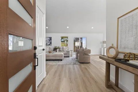 a living room with furniture and a wooden floor