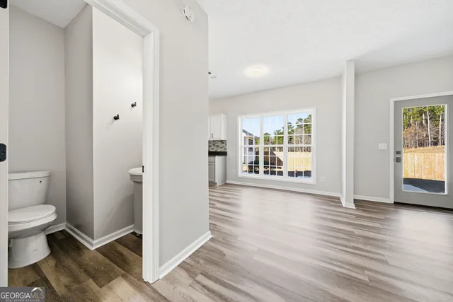 a view of empty room with wooden floor and fireplace
