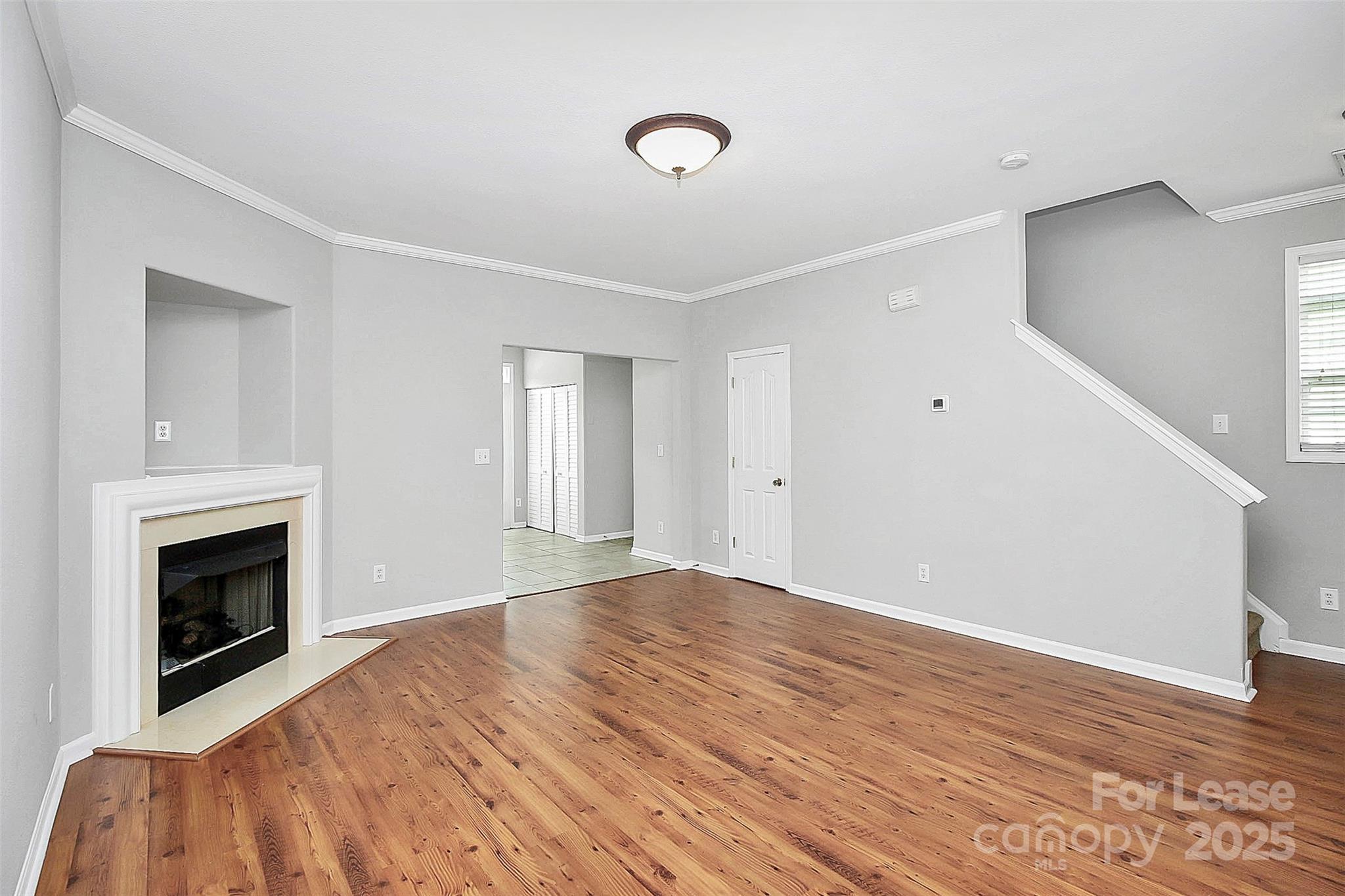 11263 Heritage Green Drive Cornelius, NC 28031 - Photo 5 of 32 a view of empty room with wooden floor and fireplace