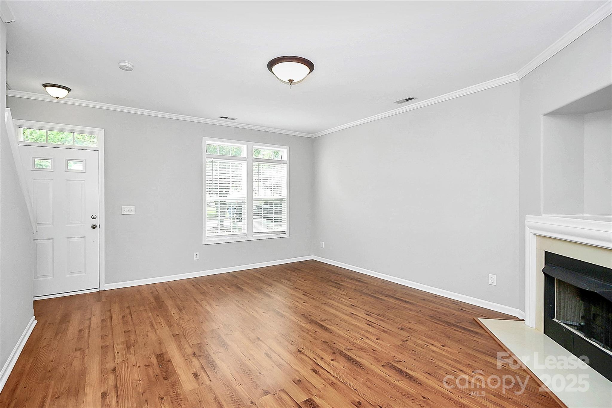 11263 Heritage Green Drive Cornelius, NC 28031 - Photo 6 of 32 a view of empty room with wooden floor and fireplace