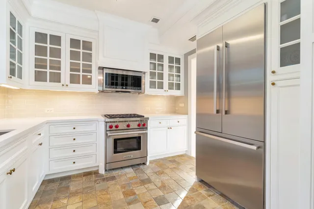 a kitchen with cabinets stainless steel appliances and a window