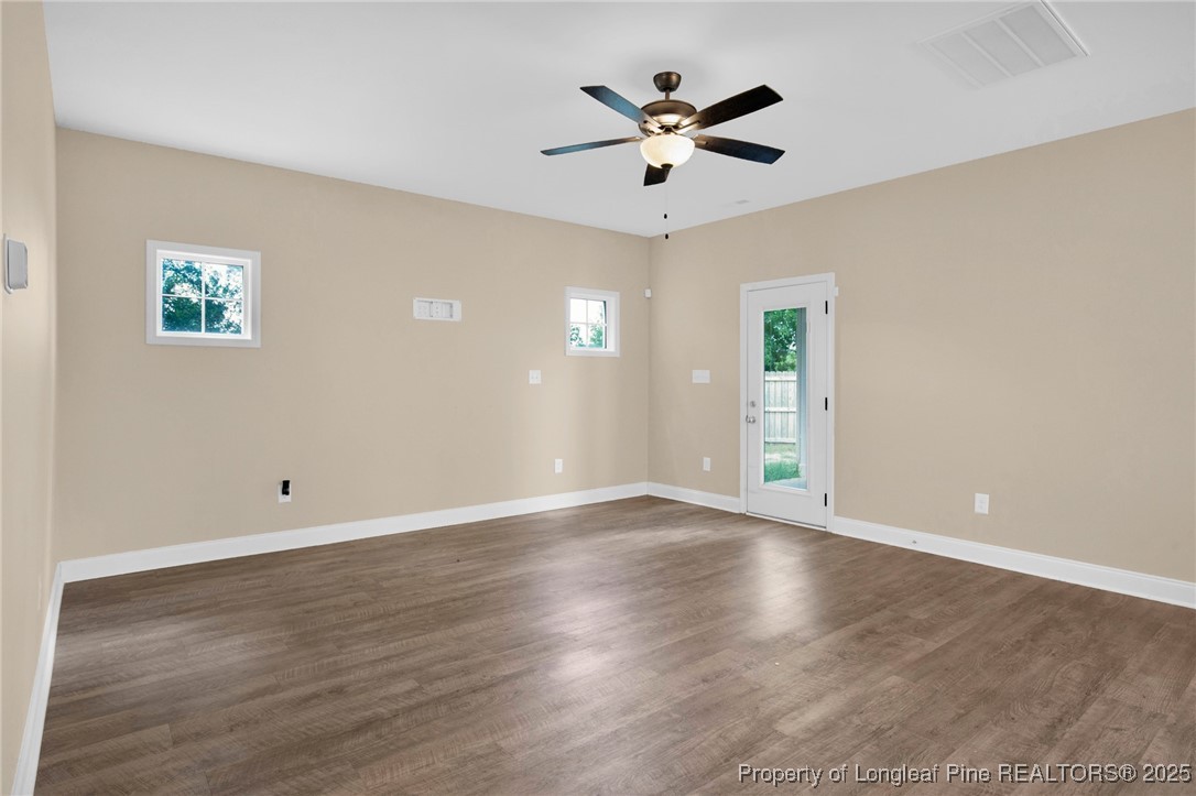 405 Shelton Beard Road Stedman, NC 28391 - Photo 8 of 36 an empty room with wooden floor and ceiling fan