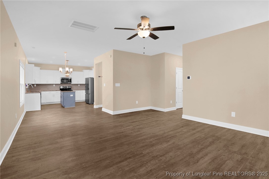 405 Shelton Beard Road Stedman, NC 28391 - Photo 10 of 36 a view of a kitchen with a sink a refrigerator a ceiling fan and wooden floor