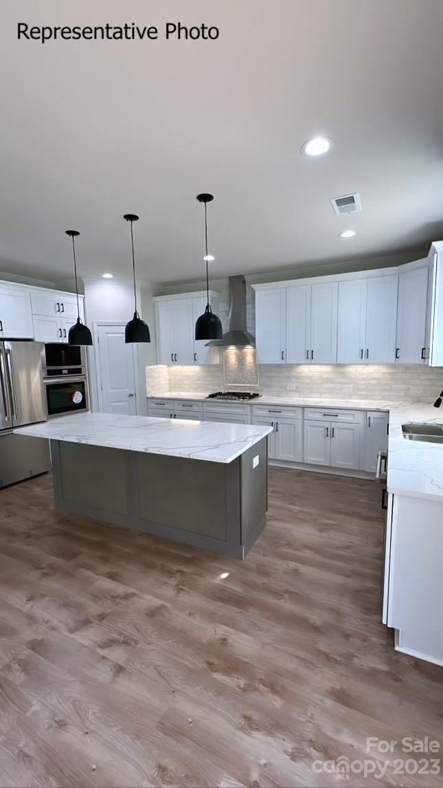 2432 Lakeview Circle Matthews, NC 28105 - Photo 10 of 20 a large kitchen with stainless steel appliances granite countertop a stove a sink dishwasher a refrigerator and white cabinets with wooden floor