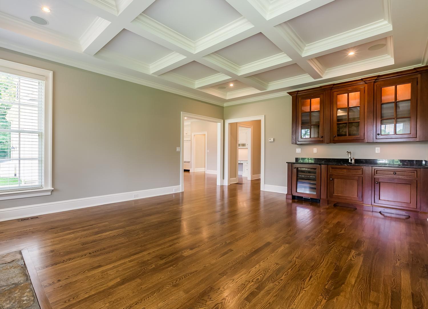 92 White Oak Shade Road New Canaan, CT 06840 - Photo 15 of 35 an empty room with wooden floor and kitchen view