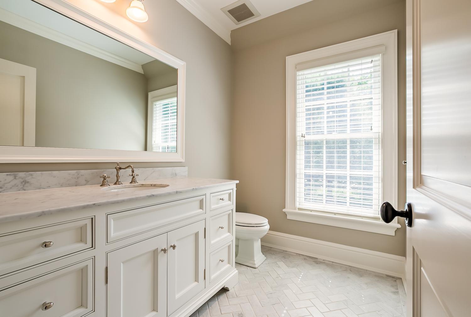 92 White Oak Shade Road New Canaan, CT 06840 - Photo 23 of 35 a bathroom with a granite countertop toilet a sink a mirror and a window