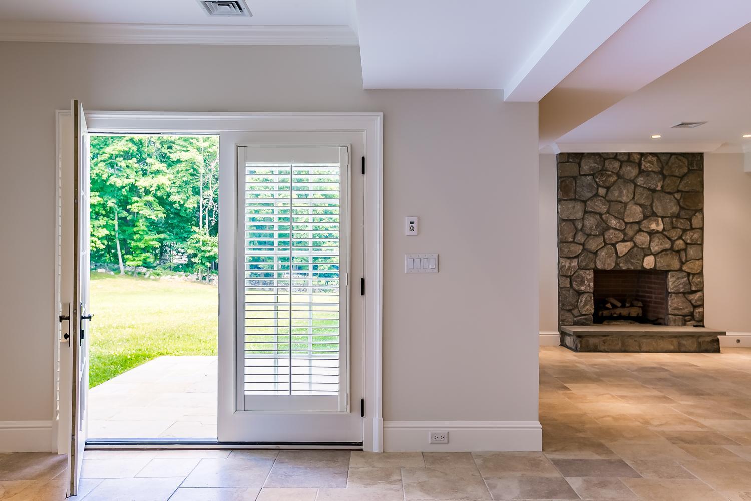 92 White Oak Shade Road New Canaan, CT 06840 - Photo 32 of 35 a view of an empty room with a fireplace and a window