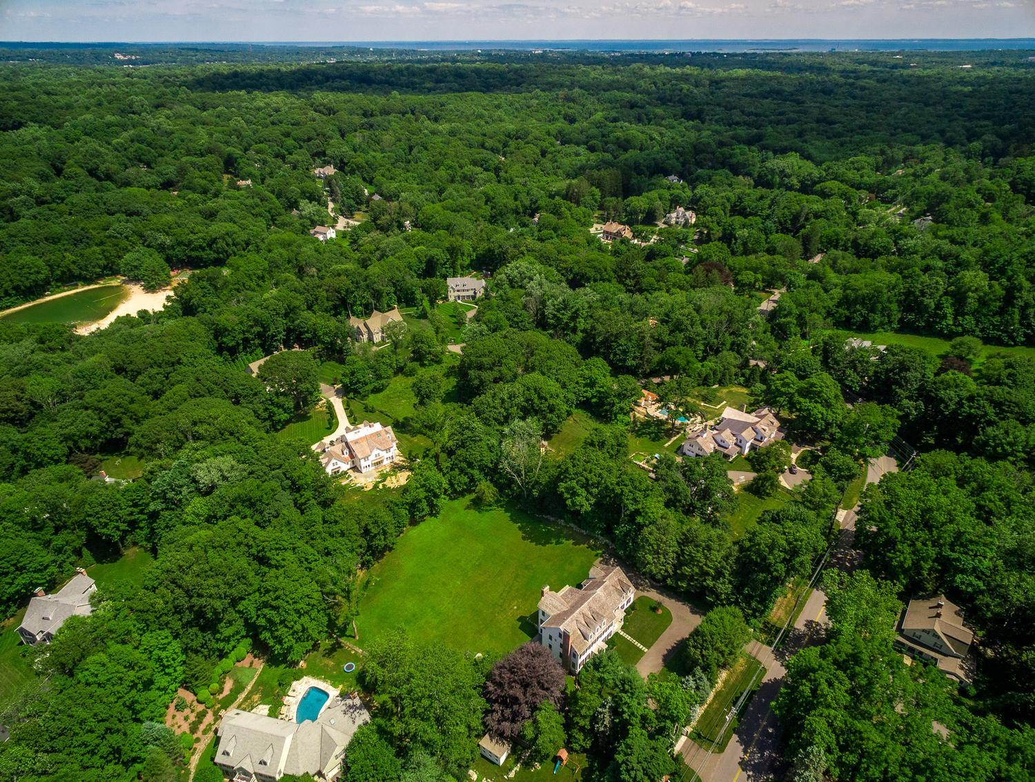 92 White Oak Shade Road New Canaan, CT 06840 - Photo 35 of 35 a view of a house with a lush green forest