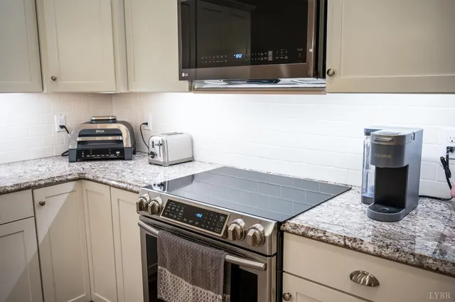 a kitchen with stainless steel appliances granite countertop a refrigerator sink and stove