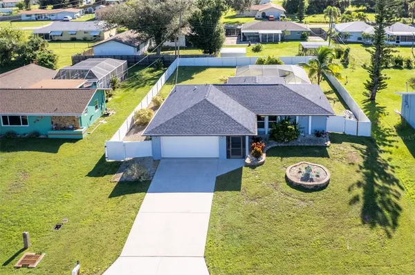 a view of a house with swimming pool lawn chairs and a yard