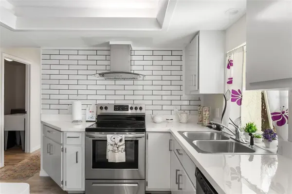 a kitchen with granite countertop a sink stainless steel appliances and cabinets