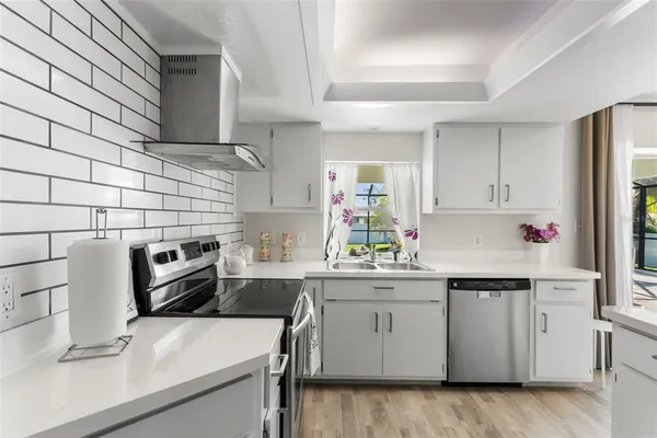 a kitchen with a sink a stove and cabinets