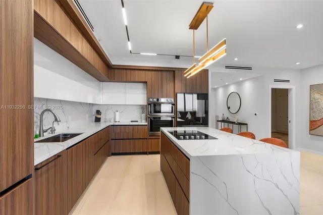 a kitchen with stainless steel appliances granite countertop a sink cabinets and wooden floor