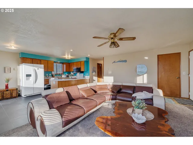 a living room with furniture kitchen view and a chandelier