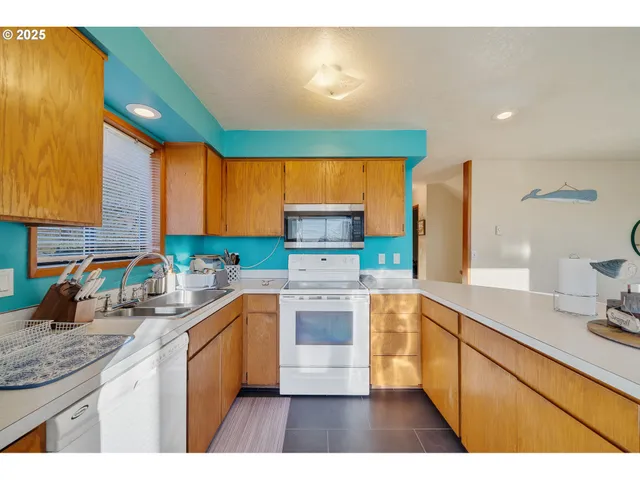 a kitchen with stainless steel appliances a sink a stove a refrigerator cabinets and a counter top space