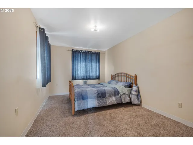 a spacious bedroom with a bed and a window