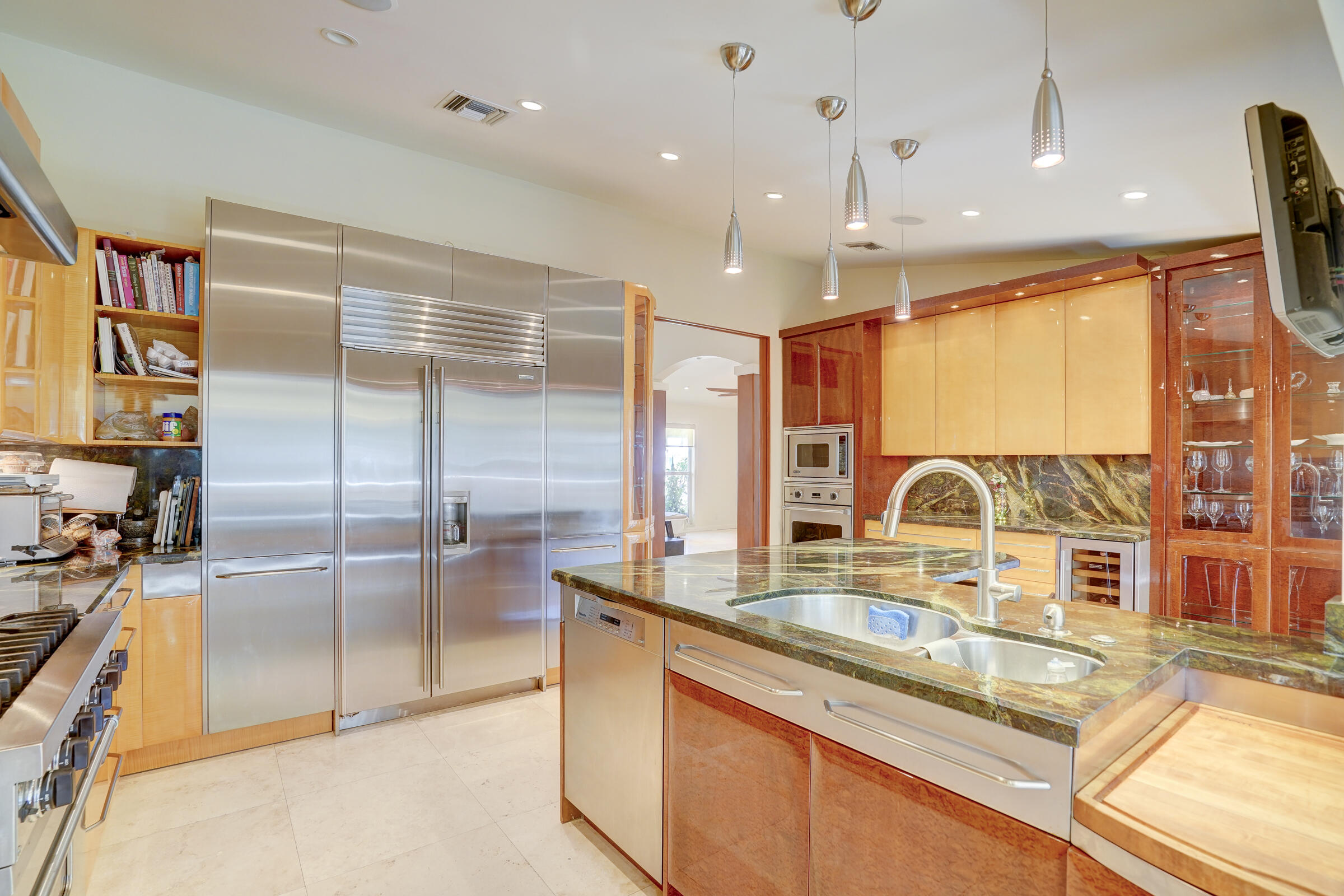 1191 Emerald Drive Singer Island, FL 33404 - Photo 19 of 60 a kitchen with kitchen island granite countertop a sink and a counter top space