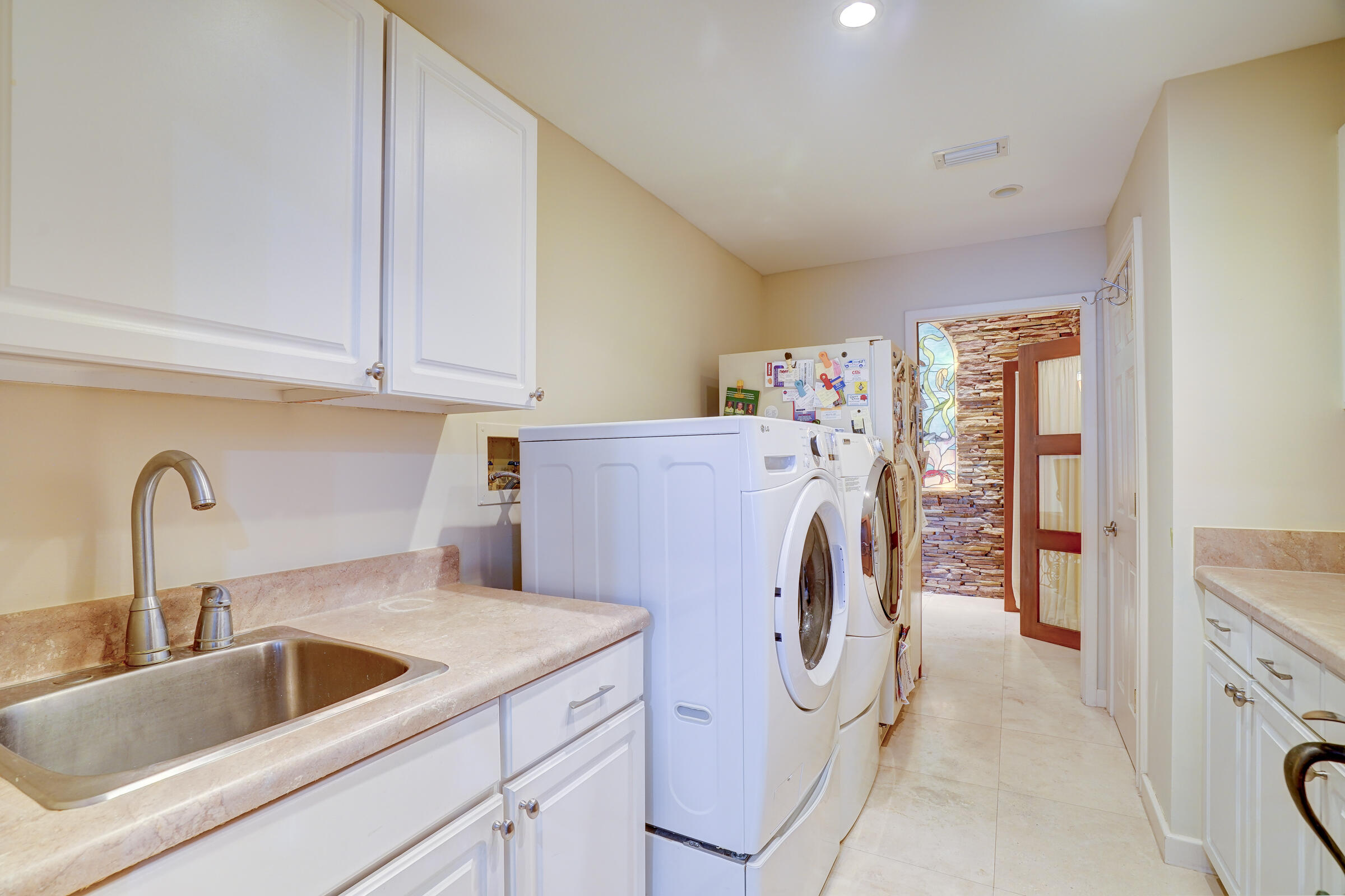 1191 Emerald Drive Singer Island, FL 33404 - Photo 37 of 60 a view of a kitchen with sink and washing machine