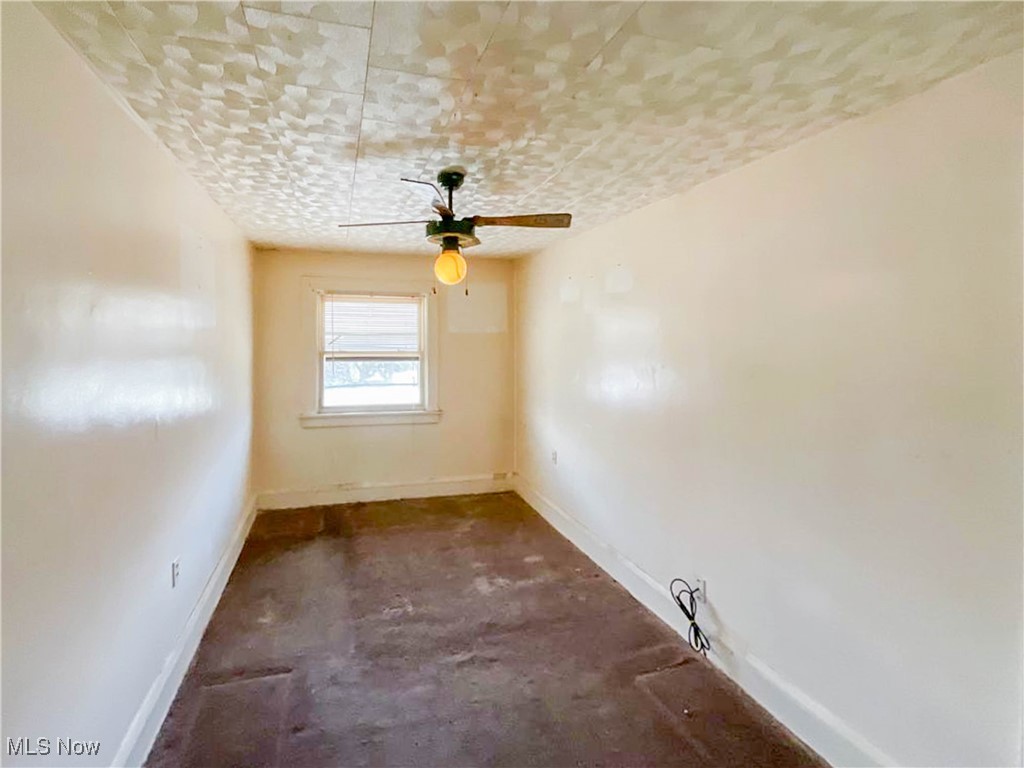14703 Granger Road Maple Heights, OH 44137 - Photo 18 of 35 Empty room with ceiling fan, baseboards, and unfinished concrete flooring