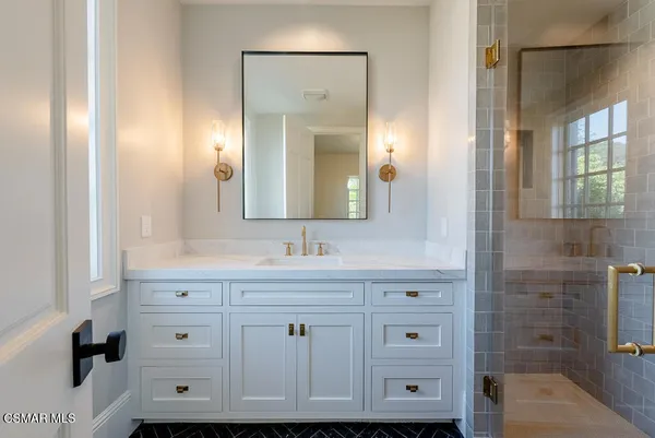 a bathroom with a sink vanity and mirror