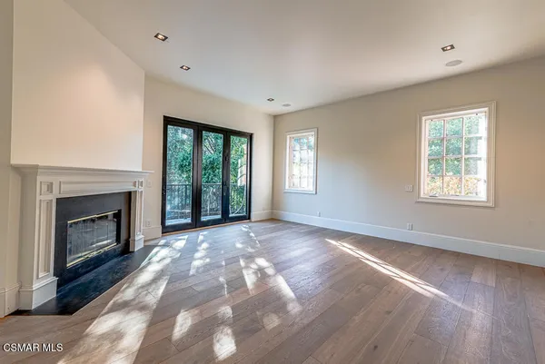 a view of empty room with wooden floor fireplace and windows