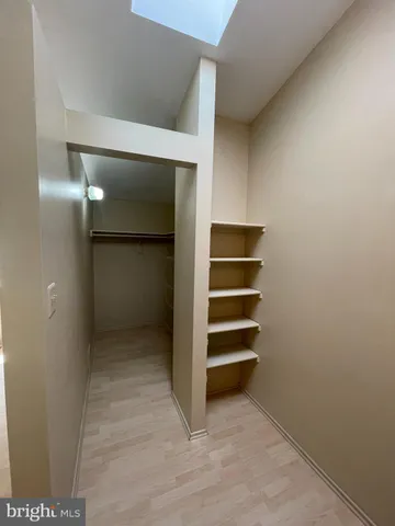 a view of walk in closet with empty racks
