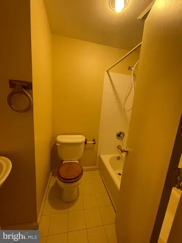 a bathroom with a granite countertop toilet and a sink