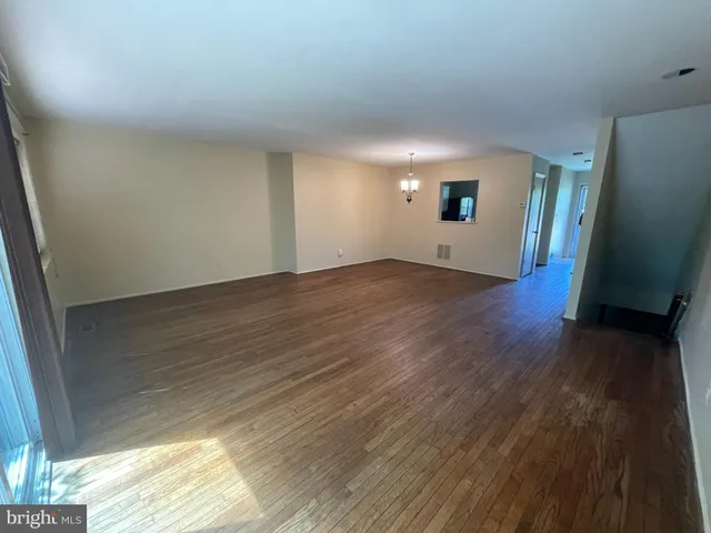 an empty room with wooden floor and a window