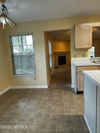 a view of livingroom with kitchen and front door
