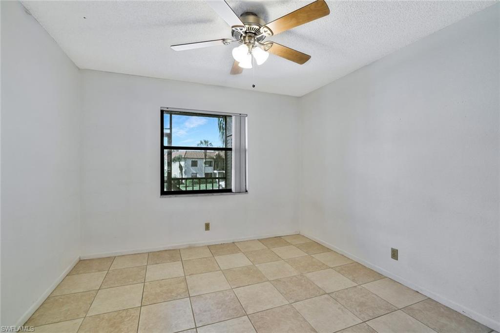 4345 27th Court Southwest, Unit 204 Naples, FL 34116 - Photo 16 of 25 a view of an empty room with window and chandelier fan