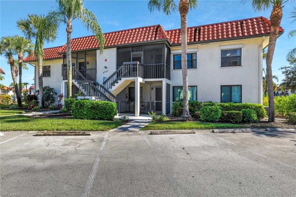 4345 27th Court Southwest, Unit 204 Naples, FL 34116 - Photo 18 of 25 a front view of a house with a yard