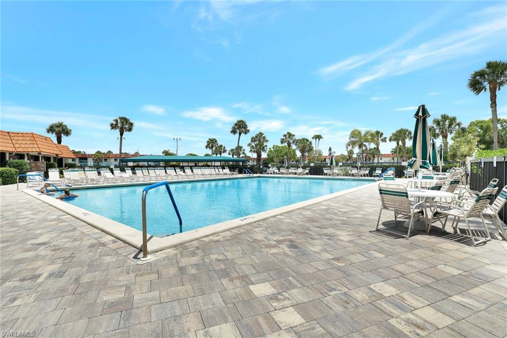4345 27th Court Southwest, Unit 204 Naples, FL 34116 - Photo 20 of 25 a view of a swimming pool with a bench and trees around