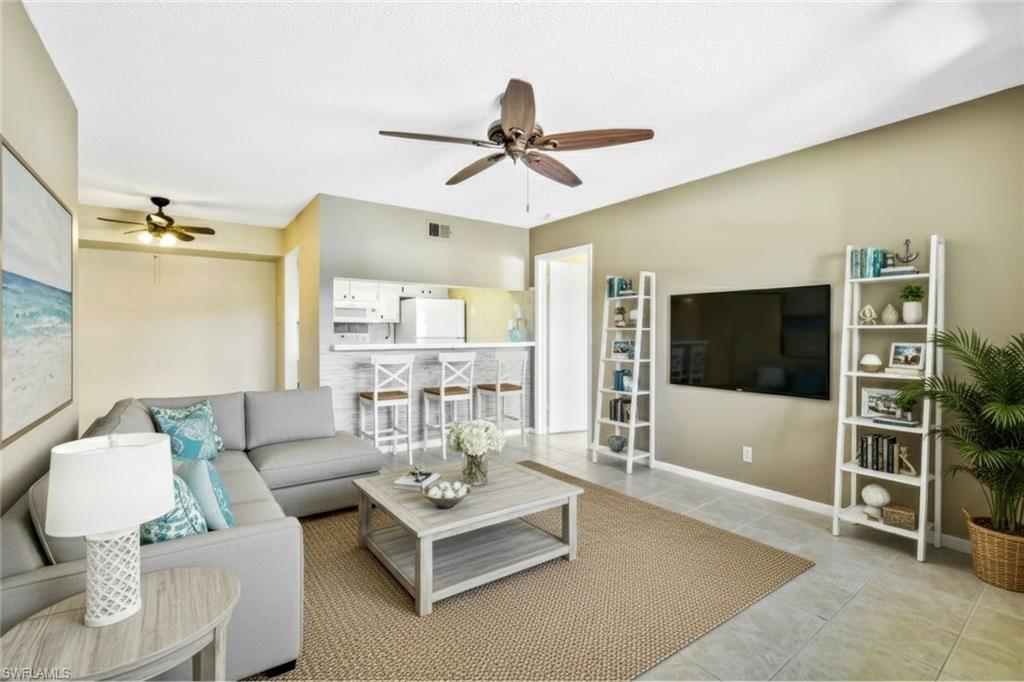 4345 27th Court Southwest, Unit 204 Naples, FL 34116 - Photo 2 of 25 a living room with furniture and a flat screen tv