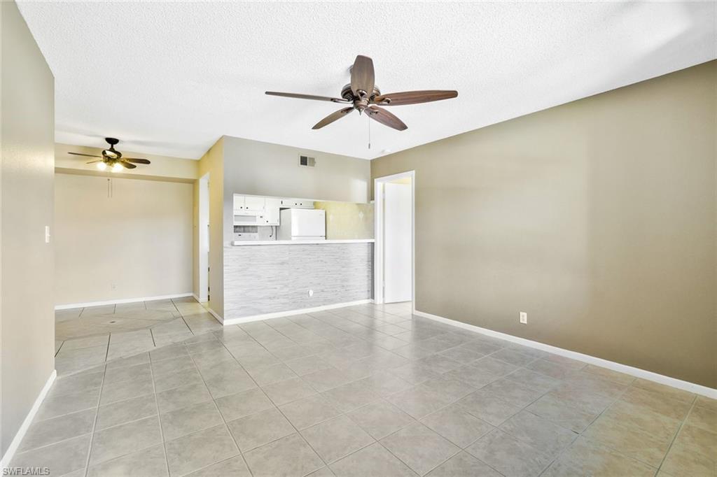 4345 27th Court Southwest, Unit 204 Naples, FL 34116 - Photo 6 of 25 an empty room with a ceiling fan and carpet
