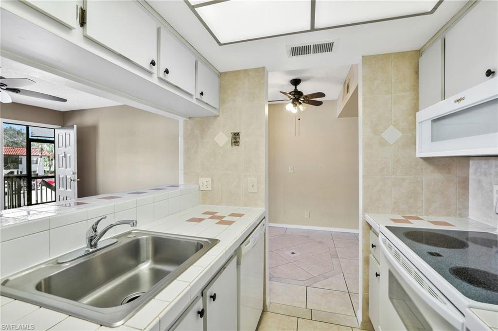 4345 27th Court Southwest, Unit 204 Naples, FL 34116 - Photo 10 of 25 a kitchen with a sink stove and refrigerator
