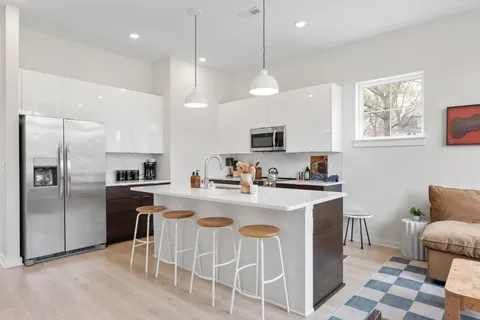 a kitchen with cabinets a sink stainless steel appliances and a window