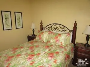 a bedroom with a bed and painting on the wall