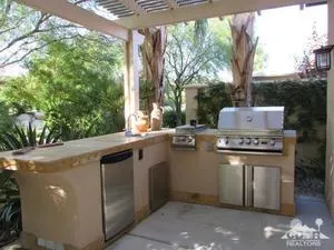 a view of a kitchen with a stove and a large tree