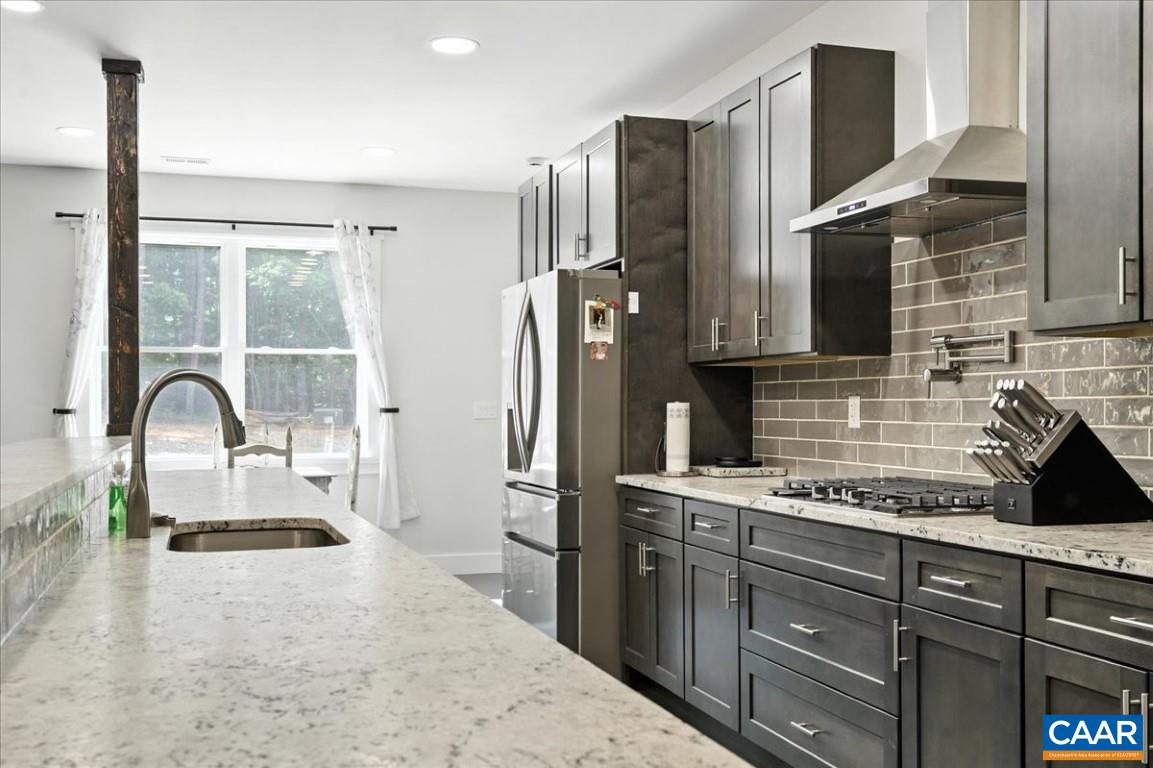 1568 Bent Creek Road Concord, VA 24538 - Photo 22 of 75 a kitchen with stainless steel appliances granite countertop a refrigerator a sink a stove and white cabinets with wooden floor