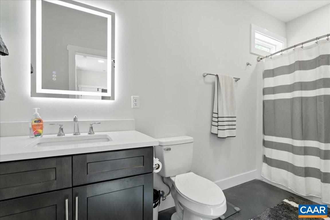 1568 Bent Creek Road Concord, VA 24538 - Photo 55 of 75 a bathroom with a toilet sink vanity and mirror