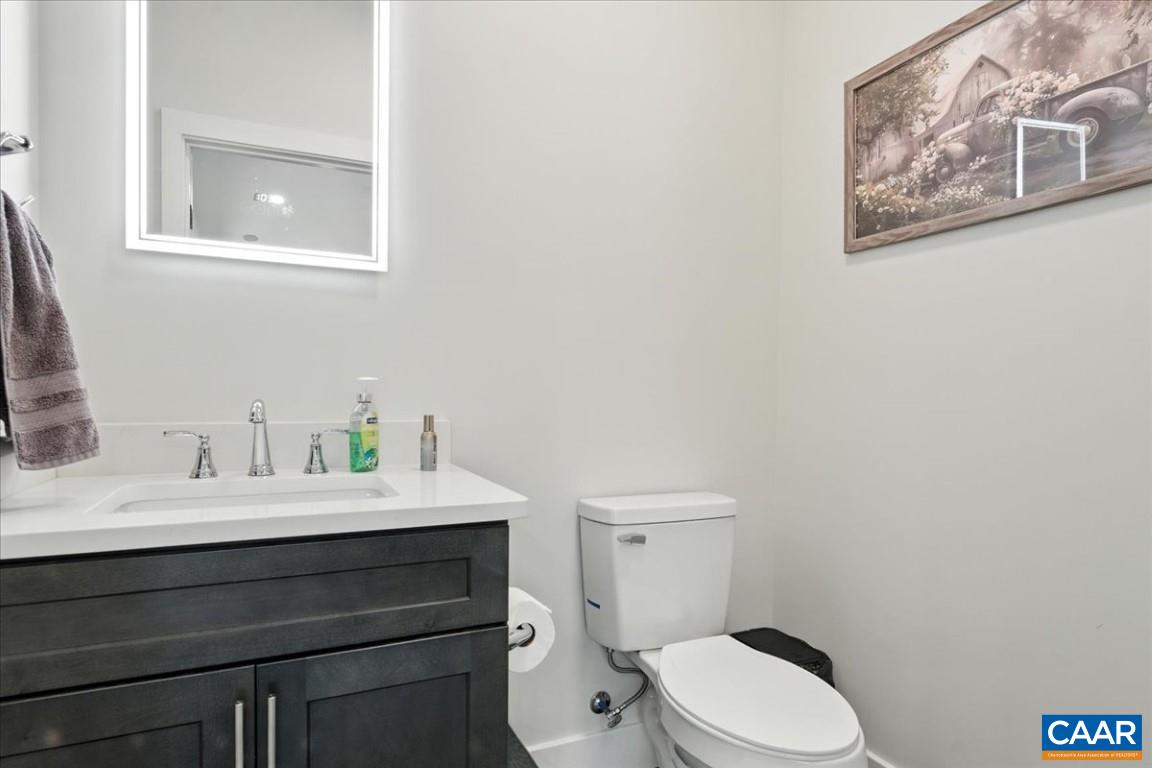1568 Bent Creek Road Concord, VA 24538 - Photo 60 of 75 a bathroom with a toilet sink vanity and mirror