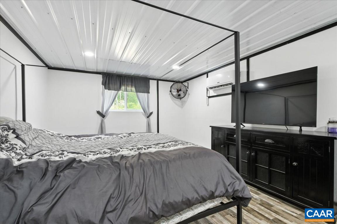 1568 Bent Creek Road Concord, VA 24538 - Photo 70 of 75 a bedroom with a bed and a flat tv screen on dresser