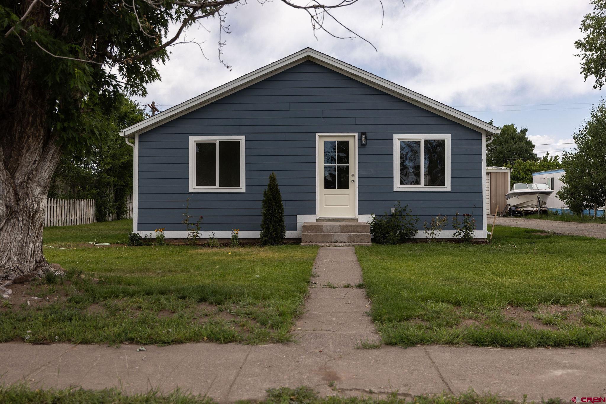 a front view of a house with a garden