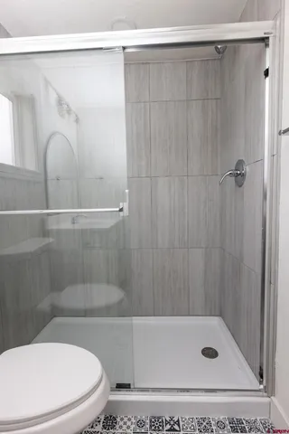 a bathroom with a shower a toilet and a sink