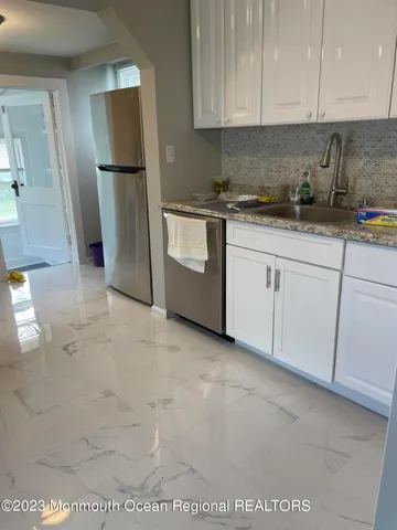 a kitchen with a refrigerator sink and cabinets