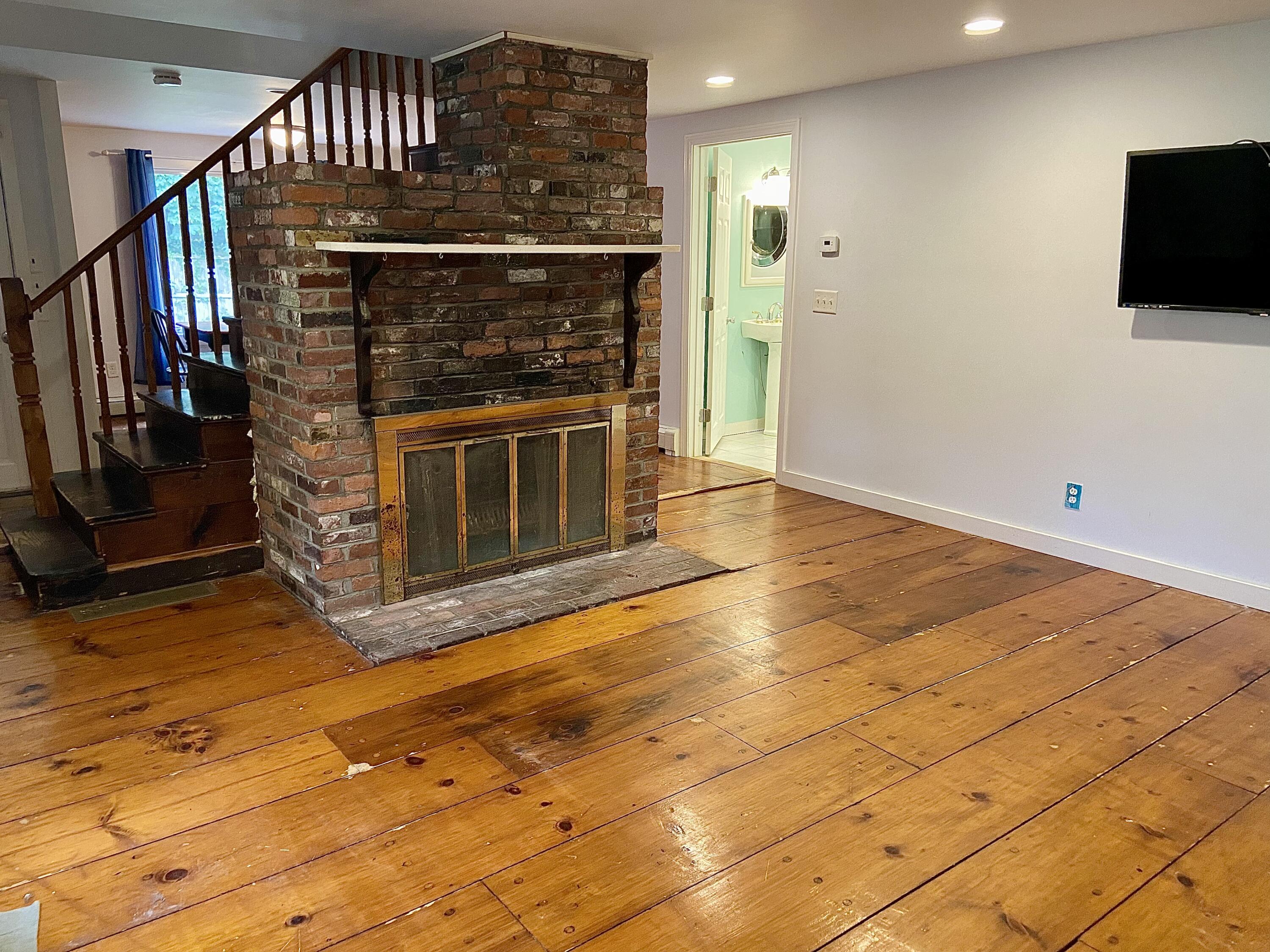 43 Bay Road Harwich, MA 02645 - Photo 15 of 24 a view of an empty room with wooden floor and a fireplace